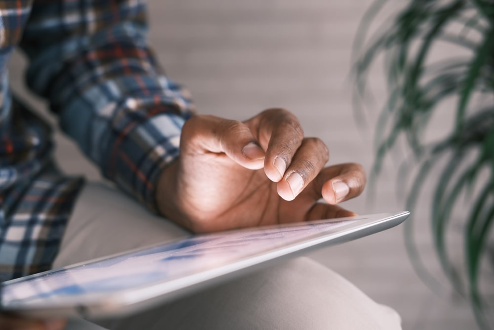 Person hat ein Tablet auf dem Schoss